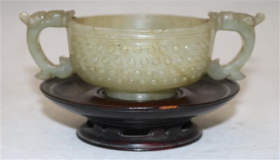 A Chinese celadon jade two handled cup, 17th century, width 12.5cm, rosewood stand